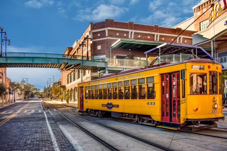 Yellow Tampa streetcar passingon street in Ybor City